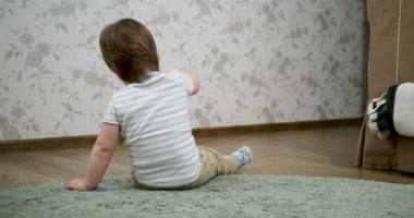 Toddler çocuk cep el feneri ile oynuyor. Bebek küçük bir cihazla meşgul. Çocuk küçük nesnelerle çalışmayı öğreniyor.