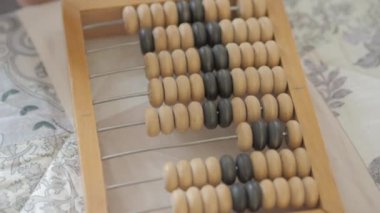 Toddler ahşap abaküs ile sayıyor. Bebek eski ahşap cihaz ile oynuyor. Çocuk saymayı öğreniyor.