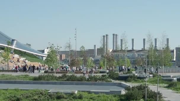 MOSCOW, RÚSSIA - 18 de maio de 2019. Zaryadye paisagem parque urbano perto de Praça Vermelha. Pessoas andando entre gramados e canteiros de flores. Cúpula de vidro de sala de concerto com anfiteatro . — Vídeo de Stock