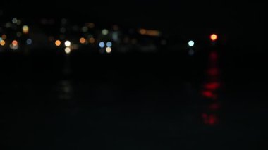 Working lighthouse in port of Yalta, Crimea. Red light flashing in night. Defocused view. Black sea.