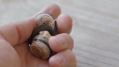 Su besleme sistemi için eski paslı hava tahliye valfi. Adam kireç le kaplı hasarlı eleman aşure dokunuyor.