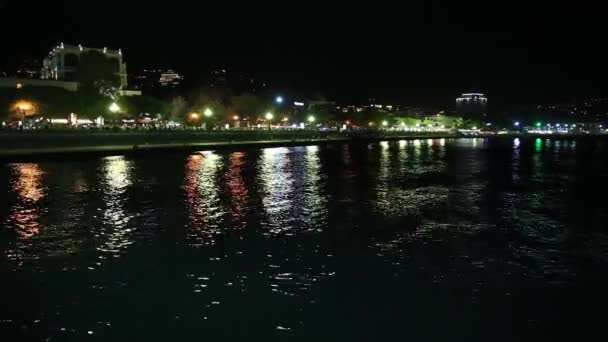 Blick auf die Stadt Jalta vom Schwarzen Meer aus. Nachtleben am Damm. Krim — Stockvideo