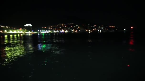 Vista panorámica de la ciudad de Yalta desde el mar Negro. Vida nocturna en terraplén. Luces desenfocadas. Crimea — Vídeos de Stock