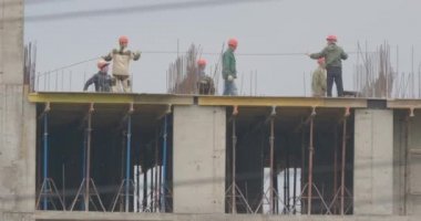 Moskova, Rusya - 22 Mayıs 2019. İlkbaharda şantiye. Turuncu üniformalı işçiler prova lar koyarlar. Kavak kabartmak uçuyor