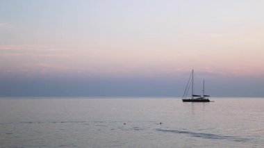 Gün batımı arka planda yat silueti. Sudak, Kırım.