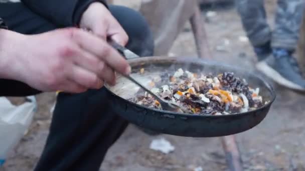 Touristen braten Pilze und Zwiebeln in einer Pfanne über dem Feuer. Lagerfeuer im Wald. — Stockvideo