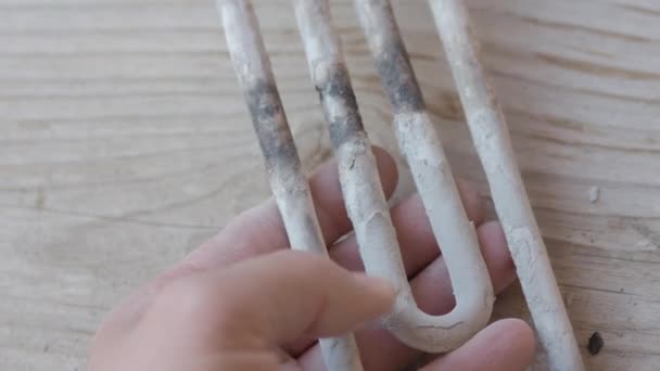 Burnt-out heating element from a washing machine. Man is touching turbular electric heating element covered with limescale. — Stock Video