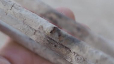 Çamaşır makinesinden yanmış ısıtma elemanı. Adam kireç ile kaplı türbülans elektrikli ısıtma elemanı dokunuyor.