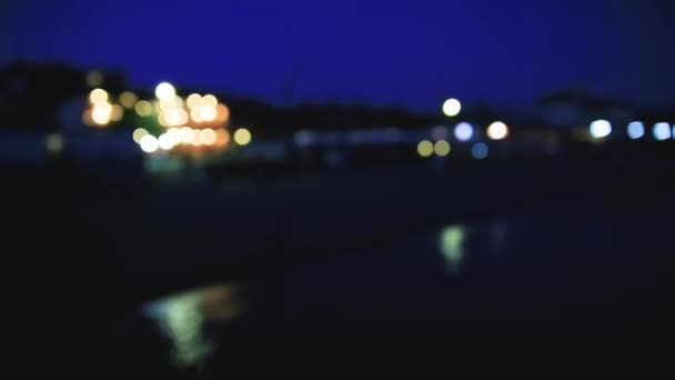 Night view on coast of Sudak town. from the Black sea. Crimea. Defocused background. — Stock Video