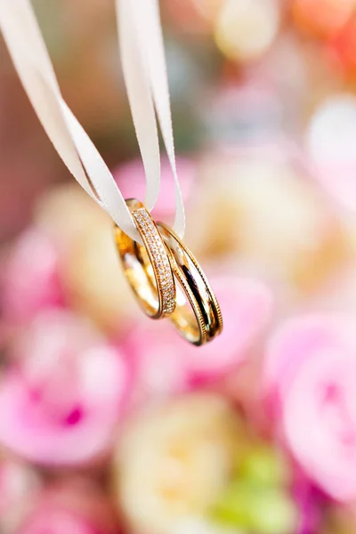 Pembe ve sarı güller ile gelin buketi altın alyans. Düğün töreni için geleneksel çiçek kompozisyonu. Aşk ve evliliğin romantik sembolü. — Stok fotoğraf