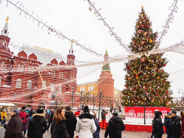 Moskova, Rusya - 30 Aralık 2018. Moskova'nın tarihi merkezinde yürüyen insanlar yeni yıl ve Noel kutlamaları için dekore edilmiştir. Manezhnaya meydanında Devlet Tarihi Müzesi yakınında Noel ağacı.