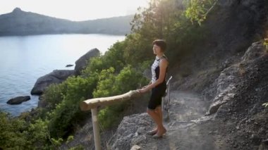 Genç kadın Golitsyn yolunda kalıyor. Şirin kız açık havada poz veriyor. Yaz günbatımında güzel manzara.