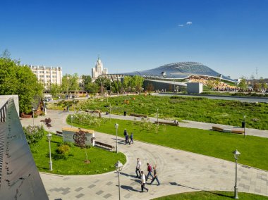 Moskova, Rusya-Mayıs 18, 2019. Kızıl Meydan yakınlarındaki Zaryadye peyzaj kentsel park Panorama görünümü. İnsanlar çimenler ve çiçek yatakları arasında yürüyor. Amfitiyatro ile konser salonu cam kubbe.