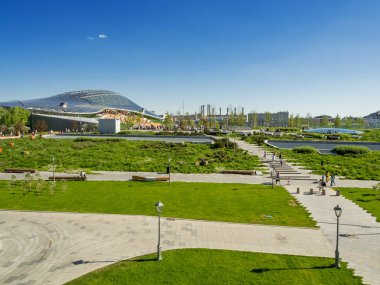 Moskova, Rusya-Mayıs 18, 2019. Kızıl Meydan yakınlarındaki Zaryadye peyzaj kentsel park Panorama görünümü. İnsanlar çimenler ve çiçek yatakları arasında yürüyor. Amfitiyatro ile konser salonu cam kubbe.