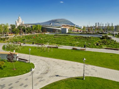 Moskova, Rusya-Mayıs 18, 2019. Kızıl Meydan yakınlarındaki Zaryadye peyzaj kentsel park Panorama görünümü. İnsanlar çimenler ve çiçek yatakları arasında yürüyor. Amfitiyatro ile konser salonu cam kubbe.