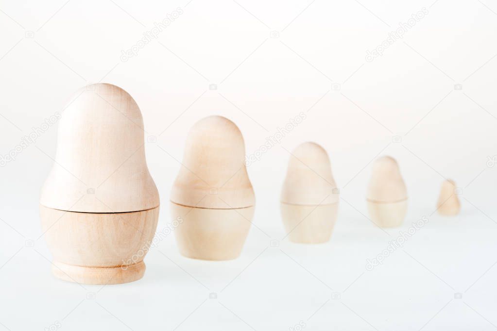 Clear wooden nesting dolls. Russian traditional toy, named matryoshka, on white background. Copy space.