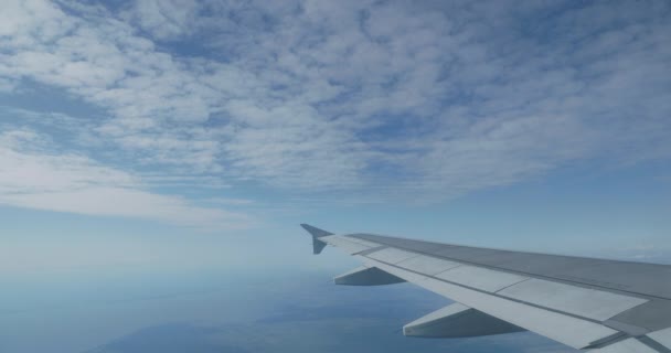 Uitzicht op blauwe lucht en pluizige witte wolken door het raam van het vliegtuig. Schilderachtig uitzicht vanaf Flying Airplane. — Stockvideo