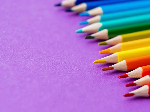 Rząd kolorowych ołówków akwarelowych na tle bzu. Materiały szkolne na fioletowym tle papieru. Papeteria dziecięca. Powrót do szkoły purpurowe tło. — Zdjęcie stockowe