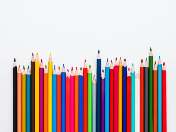 Row of colorful watercolor pencils on white background. School supplies on light paper background. Kid's stationery with copy space. Back to school backdrop. — Stock Photo, Image