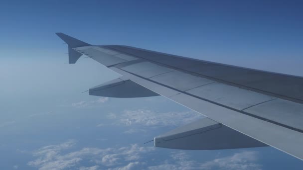 Vista sul cielo blu e soffice nuvole bianche attraverso la finestra del velivolo. Vista panoramica dall'aereo volante . — Video Stock