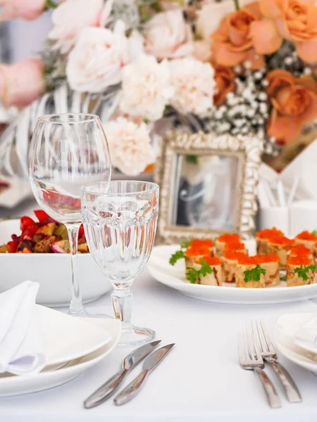 Tavola servita per banchetto nuziale con posate e fiori in vasi. Decorazioni color pastello . — Foto Stock