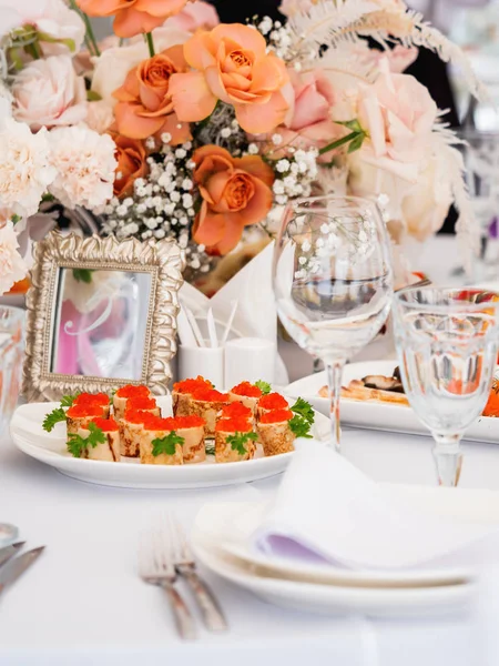 Tavola servita per banchetto nuziale con posate e fiori in vasi. Decorazioni color pastello . — Foto Stock