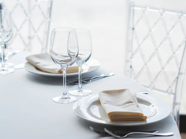 Table de banquet avec couverts, verres à vin et serviettes. Décorations de couleur pastel. — Photo