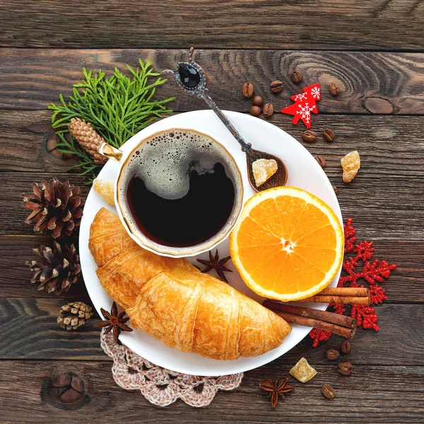 Kerstmis en Nieuwjaar 2017 achtergrond met continentaal ontbijt - kopje warme koffie met kaneel, fris oranje en croissant. Decoraties - sneeuwvlok, gehaakte servet, dennenappels. — Stockfoto