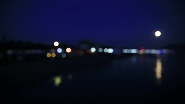 Night view on coast of Sudak town. from the Black sea. Crimea. Defocused background. — Stock Video