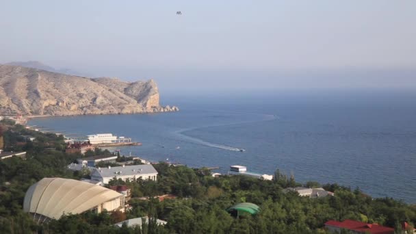 Aerial view on Sudak town from Sudak fortress. Roofs of buildings and Black sea. Crimea. — Stock Video