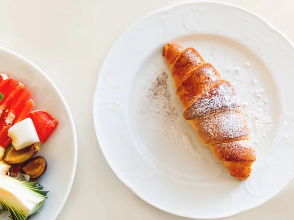 Continental breakfast - tasty croissant and plate with fresh fruits. Top view. — Stock Photo, Image