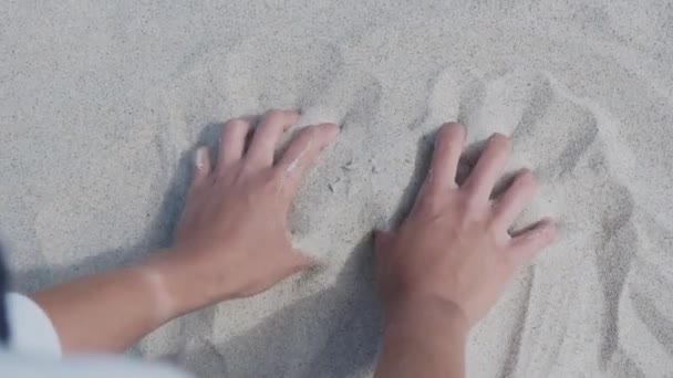 Sand rinner genom fingrarna. Kvinnan leker med sand på stranden. Tidens symbol. — Stockvideo