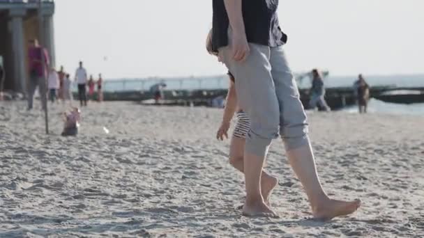 Mały chłopiec w strojach kąpielowych bawi się piaskiem na morzu. — Wideo stockowe