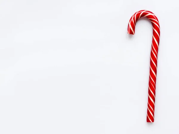Cono de caramelo de Navidad sobre fondo blanco. Colorida piruleta dulce de vacaciones con espacio para copiar. Postre con rayas rojas y blancas . — Foto de Stock