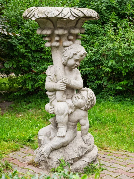 Escultura de dos ángeles frente a la torre de agua y el edificio rotundal contiguo de los baños de agua y barro. Fue construido en Rauschen (ahora Svetlogorsk ) — Foto de Stock