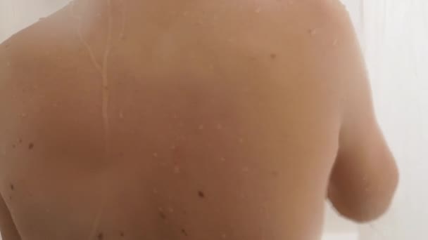 Una mujer desnuda toma una ducha. La mujer se lava el pelo corto con agua. Vídeo en cámara lenta en baño blanco . — Vídeos de Stock