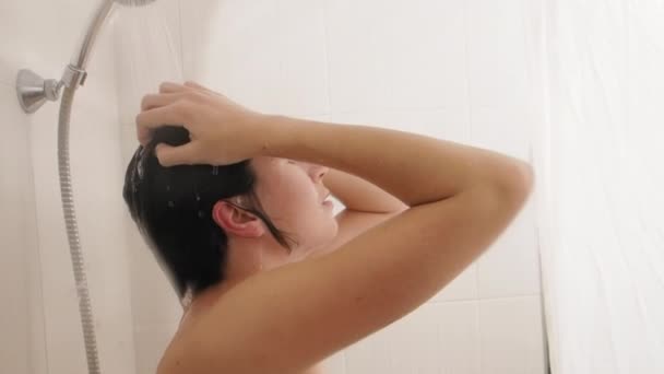 Nackte Frau duscht. Frau wäscht ihre kurzen Haare mit Wasser. Zeitlupenvideo im weißen Badezimmer. — Stockvideo