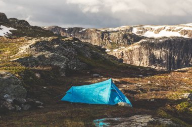 Turist çadırı dağlarda duruyor. Norveç 'teki güzel kayaların üzerinde yaz gündoğumu. 