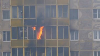 ODINTSOVO, RUSSIA - 25 Nisan 2020. Konut binasında yangın. Alevler balkon penceresinden dışarı fırladı. Kadın söndürmeye çalışıyor, suyla alev alıyor. Yavaş çekim.
