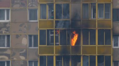 ODINTSOVO, RUSSIA - 25 Nisan 2020. Konut binasında yangın. Alevler balkon penceresinden dışarı fırladı. Kadın söndürmeye çalışıyor, suyla alev alıyor. Yavaş çekim.