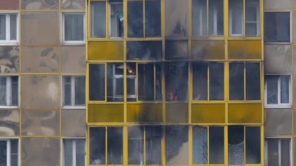 Brand in een woongebouw. De vlammen barstten uit door het balkonraam. Brandweerlieden blussen de vlam van de grond. Langzame beweging. — Stockvideo