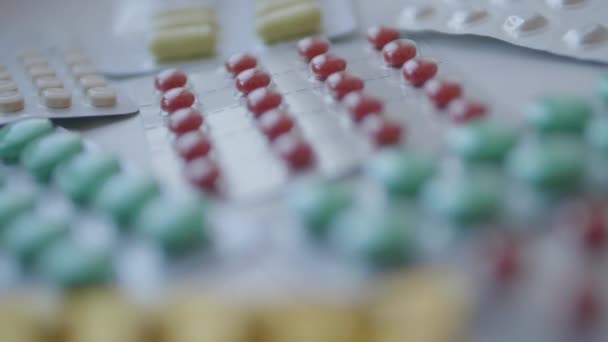 Tout-petit est assis sur le rebord de la fenêtre et joue avec des pilules de dispersion sans contrôle des parents. Situation dangereuse avec le petit garçon. Les médicaments sont disponibles gratuitement pour l'enfant.