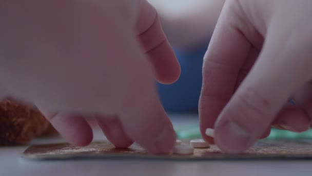 Il ragazzo gioca con lo spargimento di farmaci. Il bambino tocca le pillole senza il controllo dei genitori. Situazione pericolosa. — Video Stock