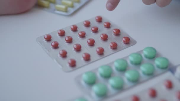 Toddler sits on windowsill and plays with scattering pills without parents control. Dangerous situation with little boy. Medicines are freely available to child. — Stock Video