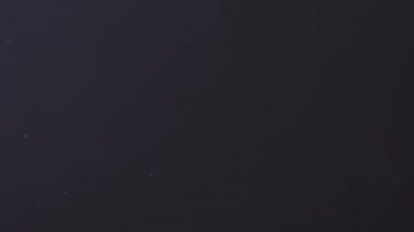 Karanlık bir arka planda havada süzülen toz. Kirli hava.