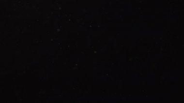 Karanlık bir arka planda havada süzülen toz. Kirli hava.