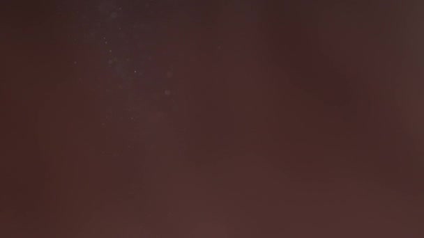 Poussière flottant dans l'air sur un fond brun. Air pollué. Véritable poussière volant au hasard.