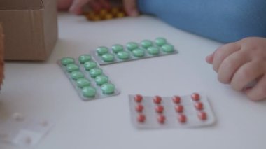 Bebek pencere eşiğinde oturur ve ebeveyn kontrolü olmadan ilaçlarla oynar. Küçük çocukla tehlikeli bir durum. İlaçlar çocuk için ücretsiz olarak mevcuttur.