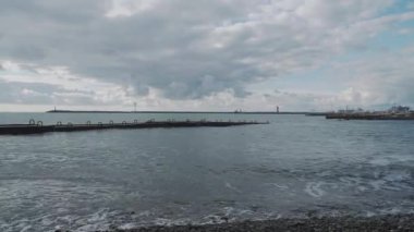 Kayalık sahilde deniz sörfü. Güneşli bir günde sakin doğal bir arka plan. Karadeniz, Soçi, Rusya.