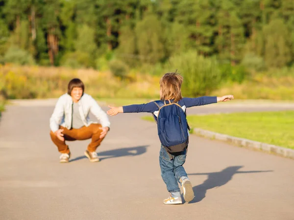 Father  picks up his son from kindergarten. Back to school after summer holidays. Family time, moral support.